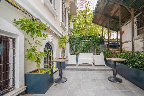 伊斯坦布尔Juno Hotel Taksim的一座庭院,楼内种有桌子和植物