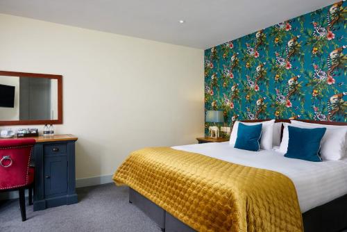 温莎The Christopher Hotel, Eton的一间卧室配有一张大床,墙上挂着一幅大画