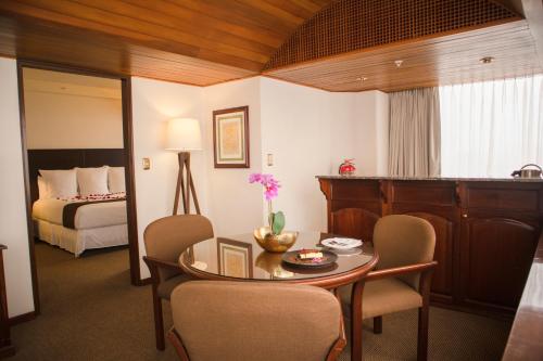 利马J&A Classic Hotel的配有桌椅和床的房间
