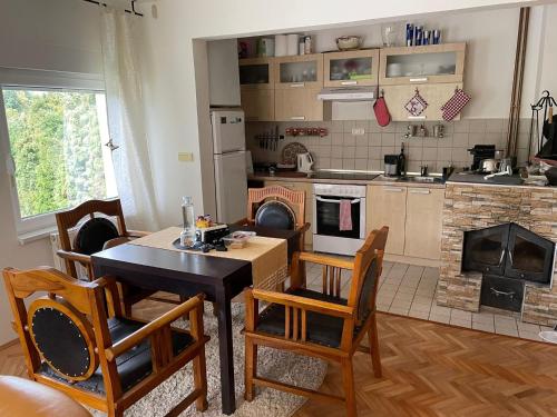 图兹拉Lexor Holiday Home的厨房配有桌椅和壁炉。