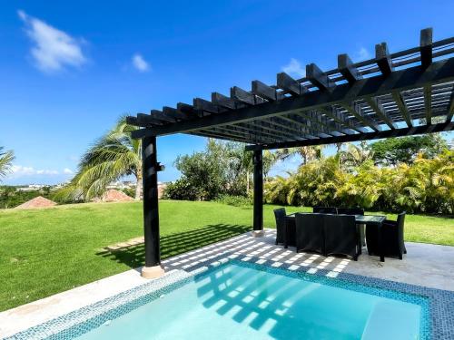 蓬塔卡纳Ileverde 21 - Private garden Bungalow的一个带桌椅的游泳池上的凉亭