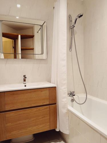 谷雪维尔Appartement La Tania的浴室配有盥洗盆和带镜子的淋浴