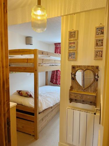 谷雪维尔Appartement La Tania的一间卧室配有两张双层床和镜子