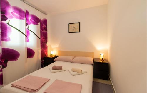 斯塔利格拉德-帕克利尼卡Awesome Home In Starigrad With House Sea View的卧室配有一张墙上紫色鲜花的床
