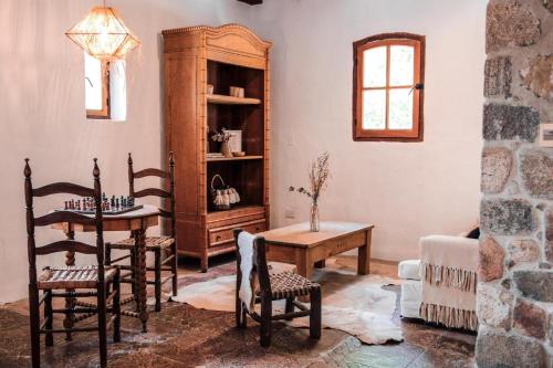 塔菲德尔瓦勒Castillo de Piedra Tafi del Valle的客厅配有桌椅和橱柜。