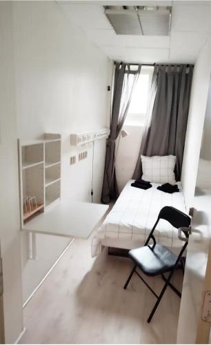 哥本哈根Bjergvænget 16, 2400 København的白色的小房间,配有床和椅子