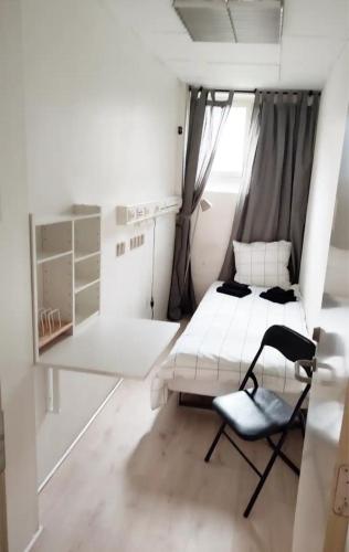 哥本哈根Bjergvænget 16, 2400 København的白色的小房间,配有床和椅子