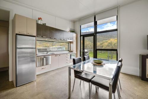 克拉肯巴克临坡克拉肯巴克3号生态可持续豪华度假屋'的厨房配有桌椅和大窗户
