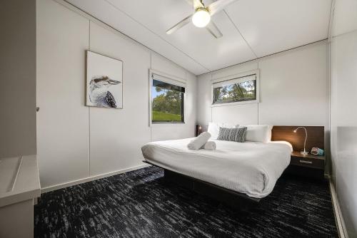克拉肯巴克临坡克拉肯巴克3号生态可持续豪华度假屋'的白色的卧室设有床和窗户