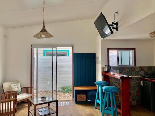 拉帕洛马Posada Agua Marina的客厅设有带蓝色凳子的厨房