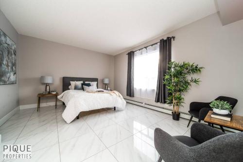 埃德蒙顿Luxury Downtown Suite, River Valley View, Patio & BBQ, Sleeps 4的一间卧室设有一张床和一个大窗户
