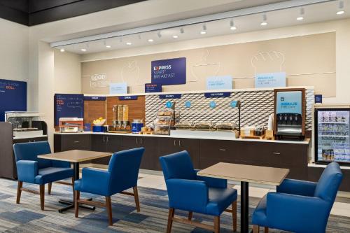 亚克朗阿克伦南机场地区快捷假日酒店及套房的一间咖啡厅,内设蓝色的桌椅和柜台
