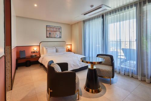 浦项Browndot Terrace Pohang Passenger Terminal的酒店客房带一张床、一张桌子和椅子