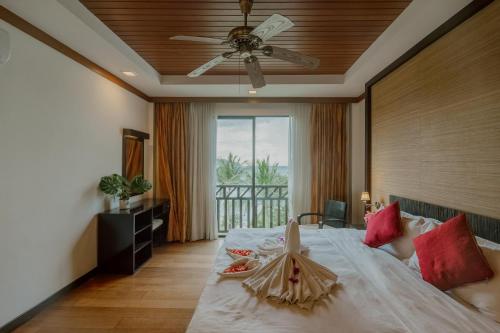 哥打京那巴鲁婆罗洲海滩别墅的一间卧室配有一张大床和吊扇