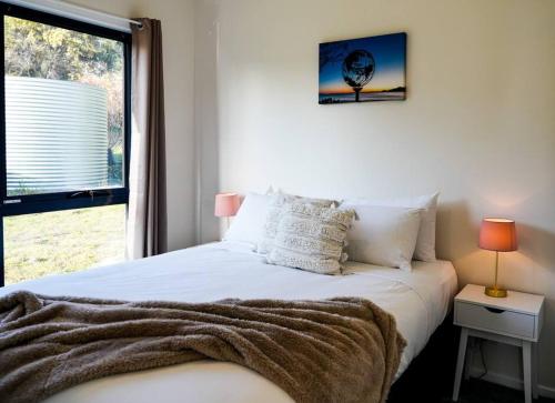LunawannaRockpool Cottage的卧室配有白色的床和窗户