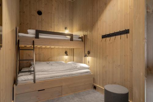 科威费耶尔Yttersvingen Kvitfjell的木墙内带两张双层床的客房