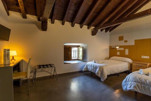 卡索拉阿尔贝格英特温卡索拉旅舍的一间卧室设有两张床、一张桌子和一个窗口。