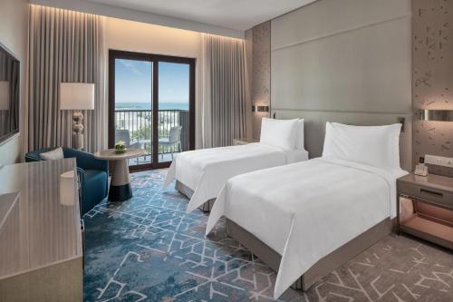 富查伊拉富吉拉海滩皇宫度假村的酒店客房设有两张床和一个阳台。
