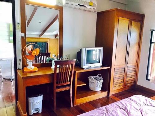象岛Koi Seahouse的一间卧室配有书桌和一台电视
