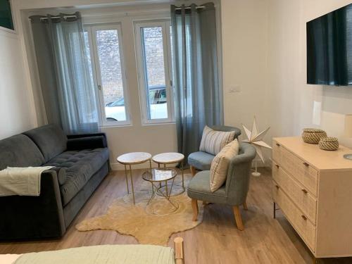 第戎Appartement chaleureux的客厅配有沙发、两把椅子和一张桌子
