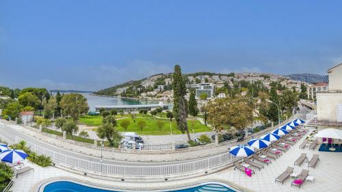 杜布罗夫尼克科墨多尔酒店的一个带游泳池、椅子和遮阳伞的度假村