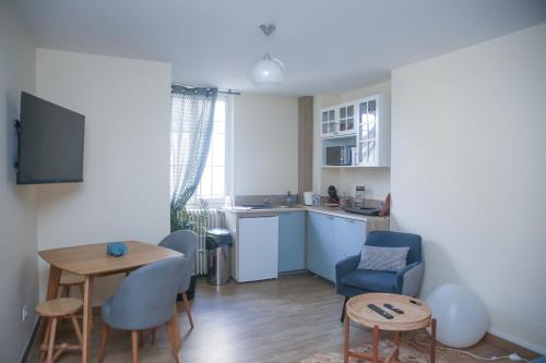 Tournan-en-BrieCROIX BLANCHE - LE LOGIS的客厅设有厨房、桌子和椅子