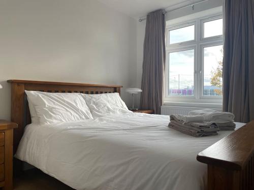 WansteadFamily friendly new flat at London Gants Hill Station near Ilford的卧室配有白色的床和窗户