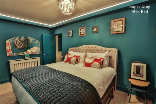 鲍内斯温德米尔The Rockefeller Apartments的一间拥有蓝色墙壁的卧室和一张带红色枕头的床