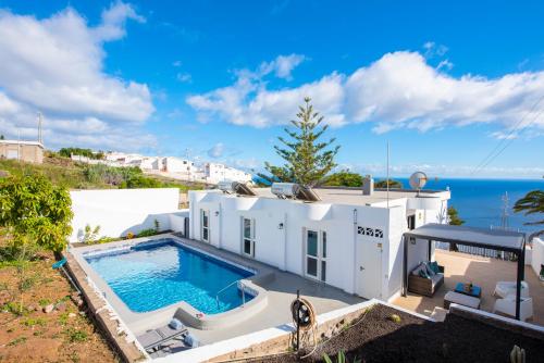 塔瓦伊瓦Villa Verode - Private Heated Saltwater Pool的白色的房子,设有一个游泳池和大海