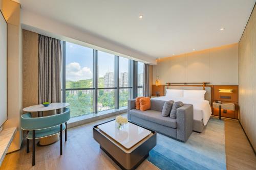 珠海珠海粤海假日酒店的酒店客房,配有床和沙发