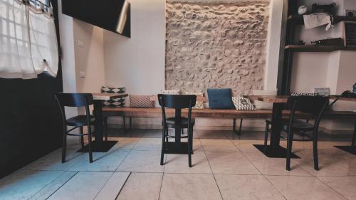 巴多利诺Bardoliners的酒吧配有黑色椅子和木桌