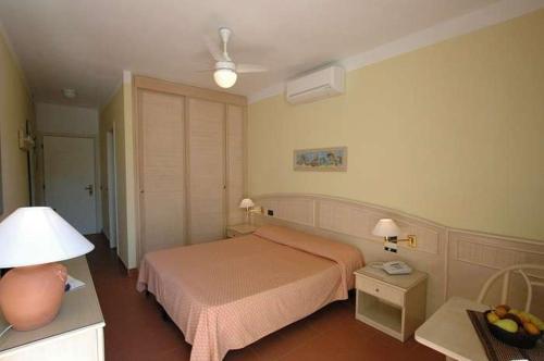费拉约港维迪斯奥酒店的一间卧室配有一张床和一张带台灯的桌子