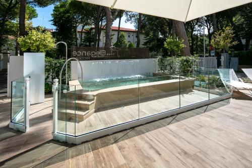里乔内Elegance Riccione的天井玻璃围墙内的热水浴池