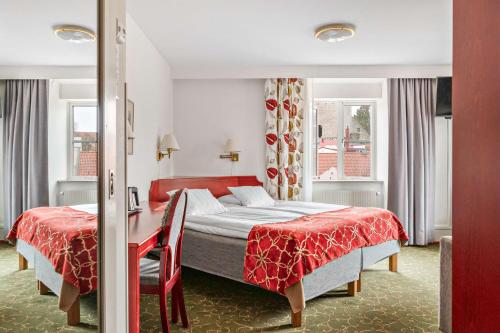 维斯比斯特兰德贝斯特韦斯特酒店的一间卧室配有两张床和红色的床罩