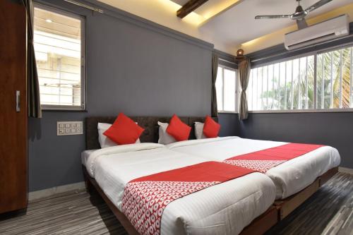 索拉普Hotel Ashirwad, Solapur的一间卧室配有一张带红色枕头的大床