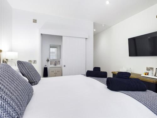 罗斯奈格尔Driftwood Boutique Guest House的卧室配有一张白色大床和两张蓝色椅子