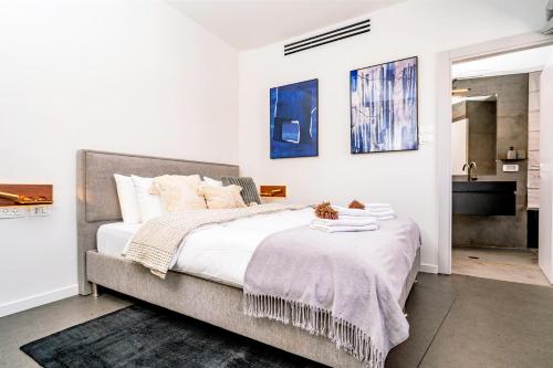 特拉维夫New Duplex 3 Bedroom with Jacuzzi的一间卧室配有一张带白色床单的大床