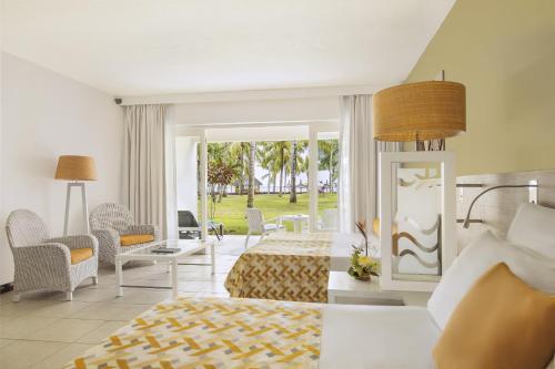 潘托皮芒Victoria Beachcomber Resort & Spa的卧室配有一张床和一张桌子及椅子