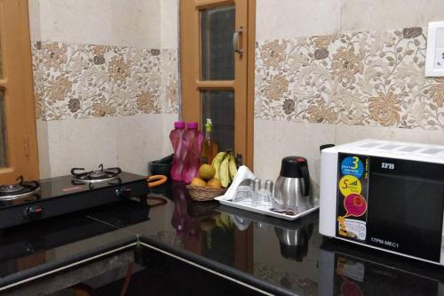 ChariHeavenly Holiday Villa - with parking的厨房柜台配有微波炉和一碗水果