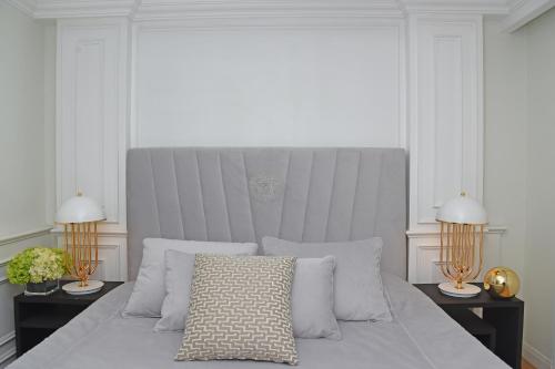贝鲁特Versace Tower Luxury Suites - Downtown的白色卧室配有一张带两盏灯的大床