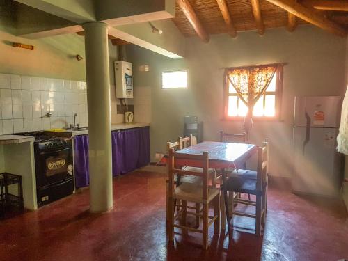 蒂尔卡拉Lo del Gaucho的厨房配有桌椅和炉灶。