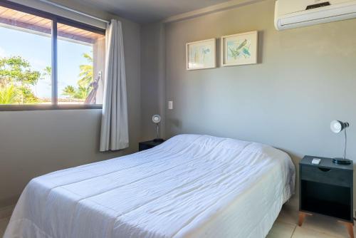 嘎林海斯港Praia Central Porto de Galinhas的卧室配有白色的床和窗户。