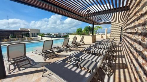 普拉亚卡门Syrena Luxury Caribbean的庭院里设有一组椅子,还有一个游泳池