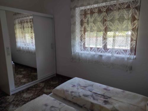 鲍洛通费尼韦什Holiday home in Balatonfenyves 18431的一间卧室配有镜子、窗户和一张床