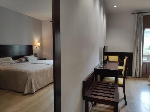 别尔萨Snö Hotel Bielsa的卧室配有1张床、1张桌子和1把椅子
