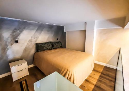 马德里Tofi 2的一间小卧室,配有一张床和一张玻璃桌