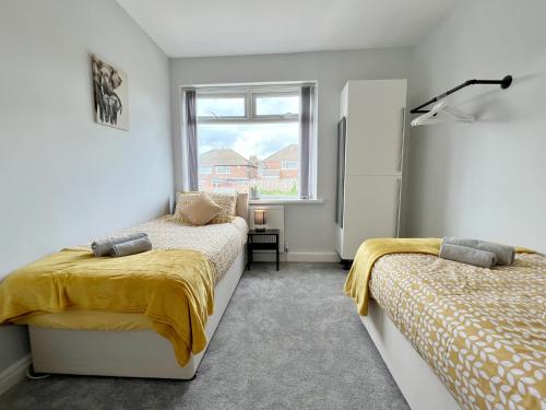 米德尔顿Cheerful 3 bedroom home with Netflix and Wi-Fi的一间卧室设有两张床和窗户。