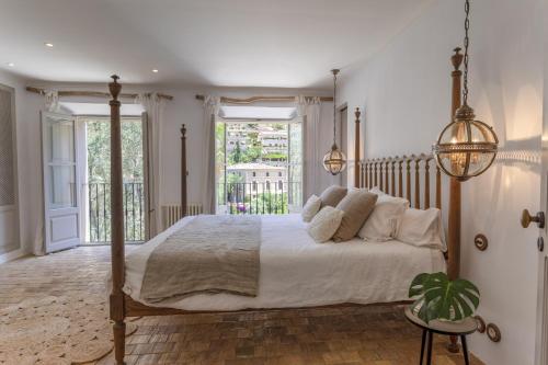 德阿Casa Berne - Deia的一间带大床的卧室和一个阳台