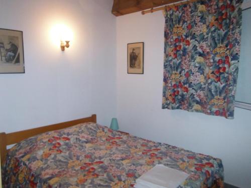 卡尔维Le Râteau Bavoir的一间卧室配有一张带五颜六色棉被的床
