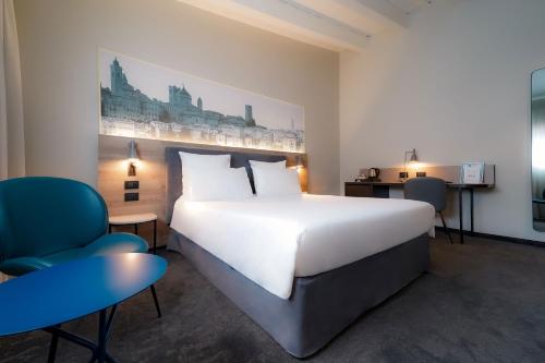 贝加莫贝加莫中心多尔斯宫美居酒店 的卧室配有一张白色大床和一张蓝色椅子